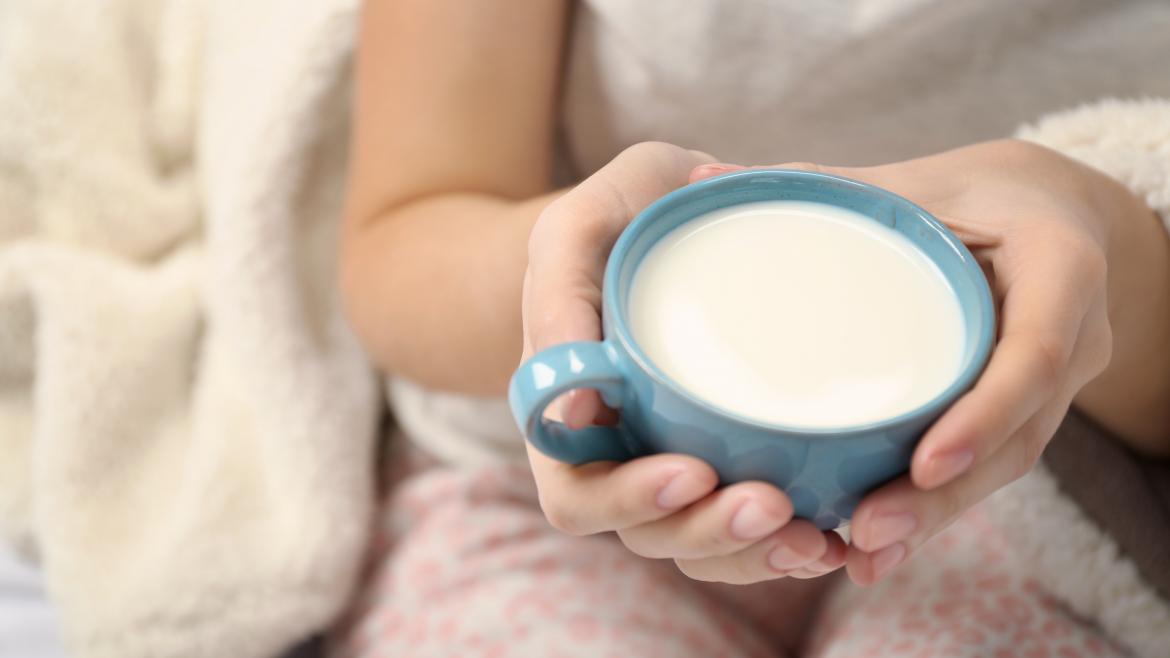 manos sujetando taza de leche