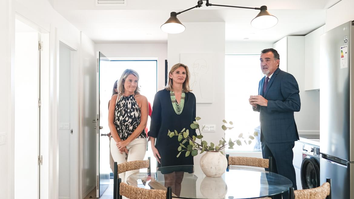 La consejera Paloma Martín dentro de una de las viviendas modulares con otras personas