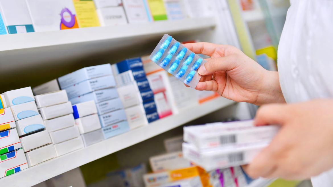 Las manos de una farmaceútica cogiendo unas cajas de medicinas