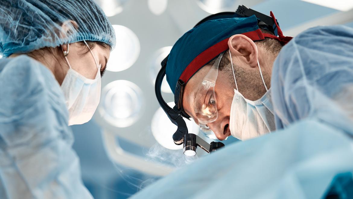 Unos médicos operando en un quirófano con sus gafas y mascarillas