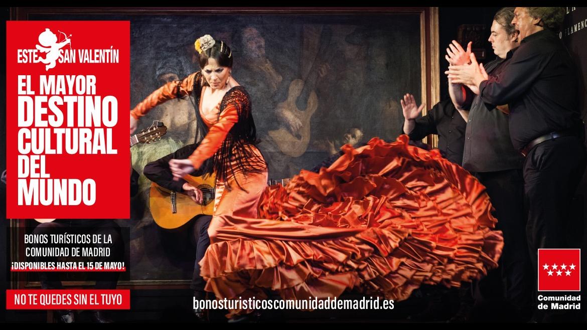 Una bailaora bailando con una bata de cola roja en movimiento junto a los músicos
