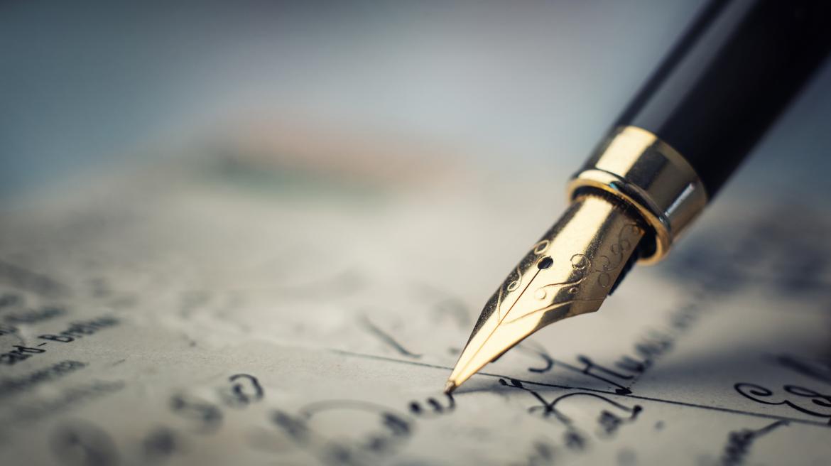 Una pluma escribiendo un texto