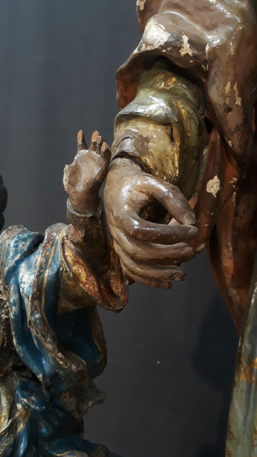 detalle de las manos de una escultura con grietas y pérdida de dedos