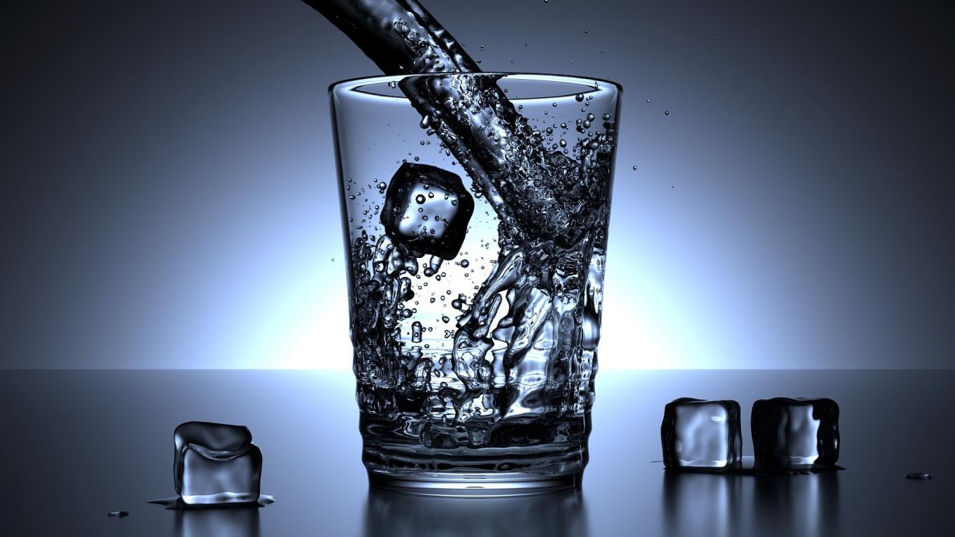 Imagen a contraluz de un vaso de agua y unos cubitos de hielo en una mesa