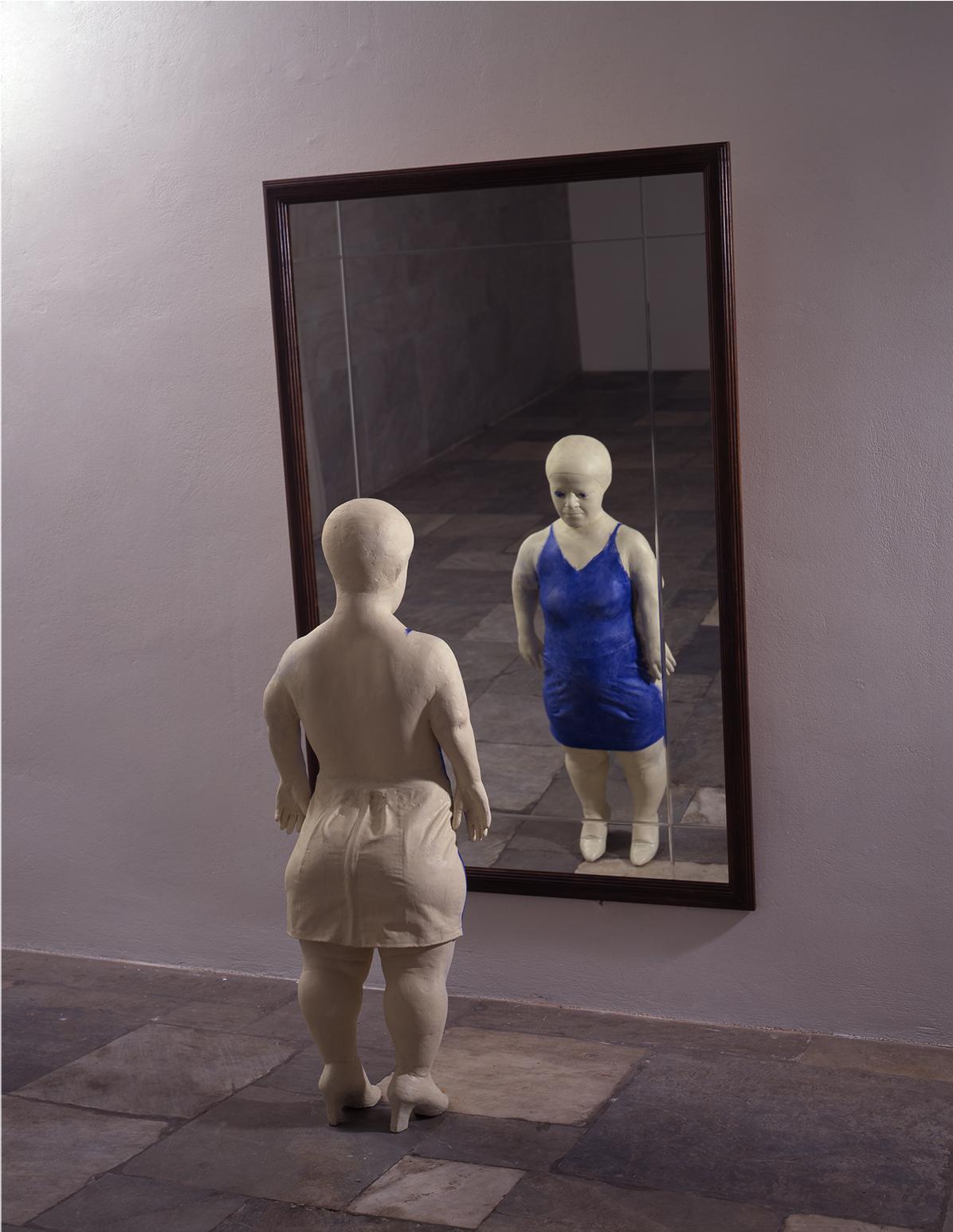 Sculpture of a woman looking in the mirror