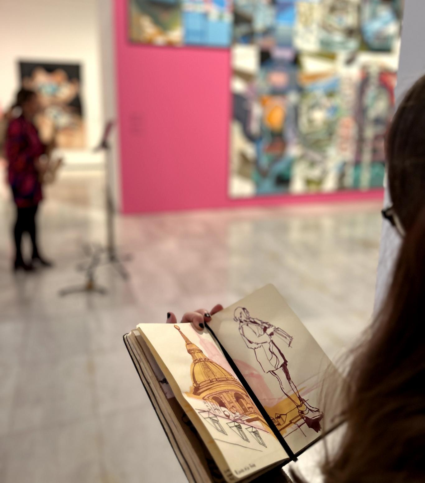 Mujer dibujando a una saxofonista en una sala de exposiciones
