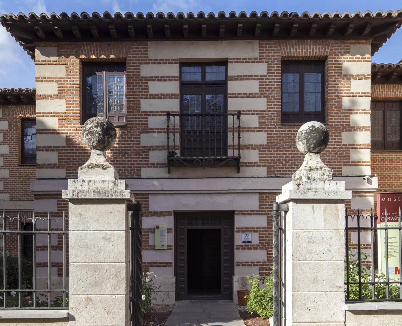 Fachada de una casa de dos plantas con ladrillo rojo y pieza blanca