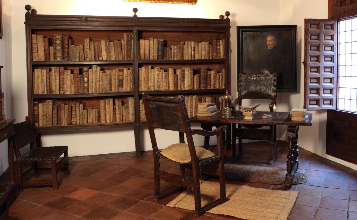 Imagen de habitación con estantes con libros y mesa