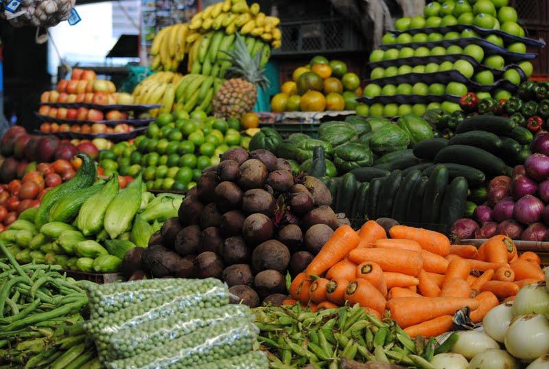 Imagen en color de un puesto de mercado lleno de frutas y verduras