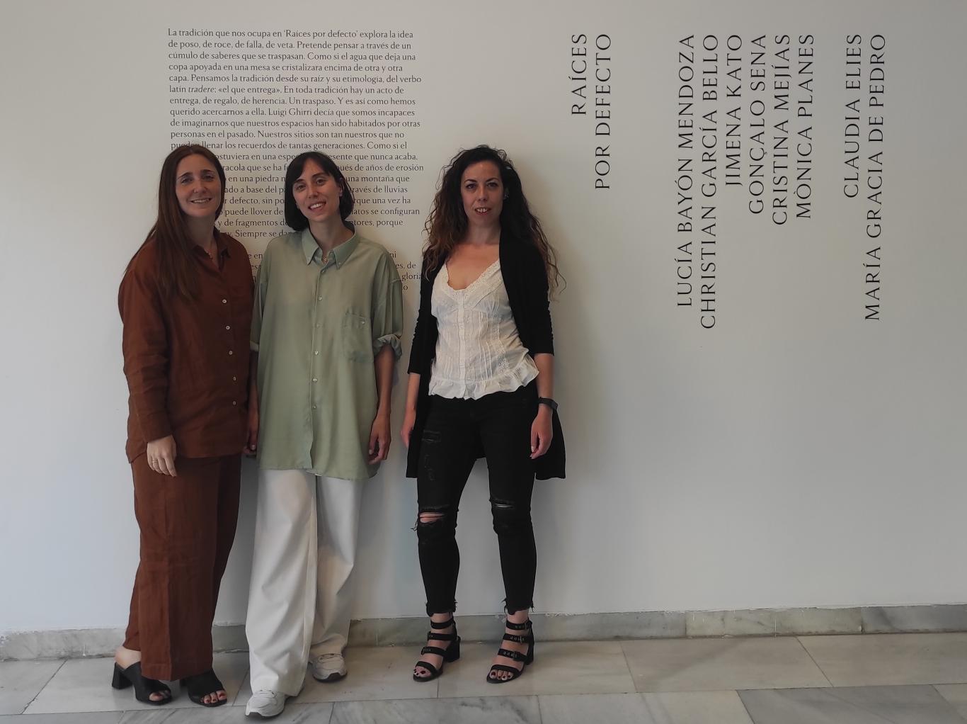 Tres mujeres jóvenes posando en una sala de exposiciones