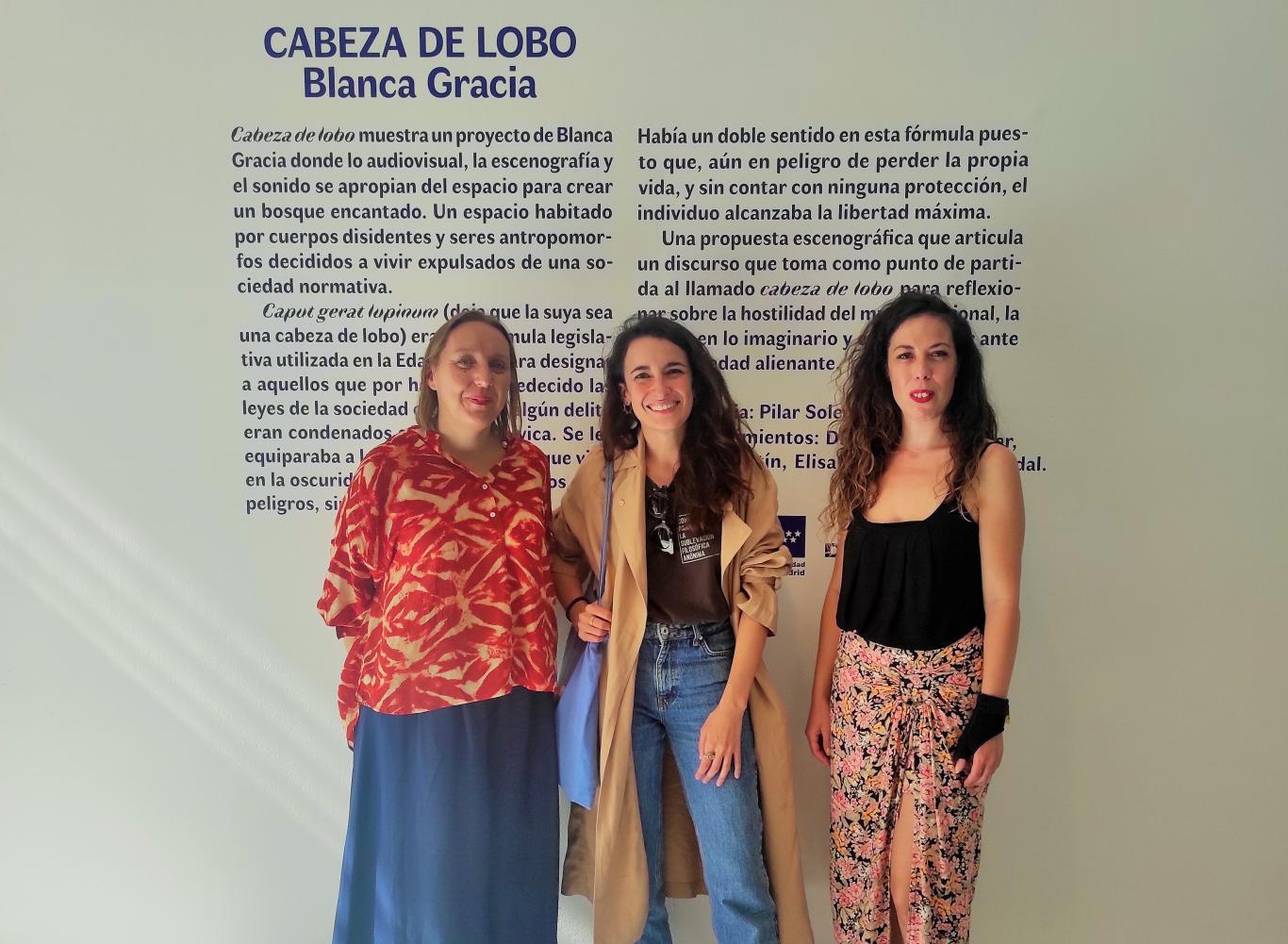 Tres mujeres posando frente a un cartel donde se lee Cabeza de lobo