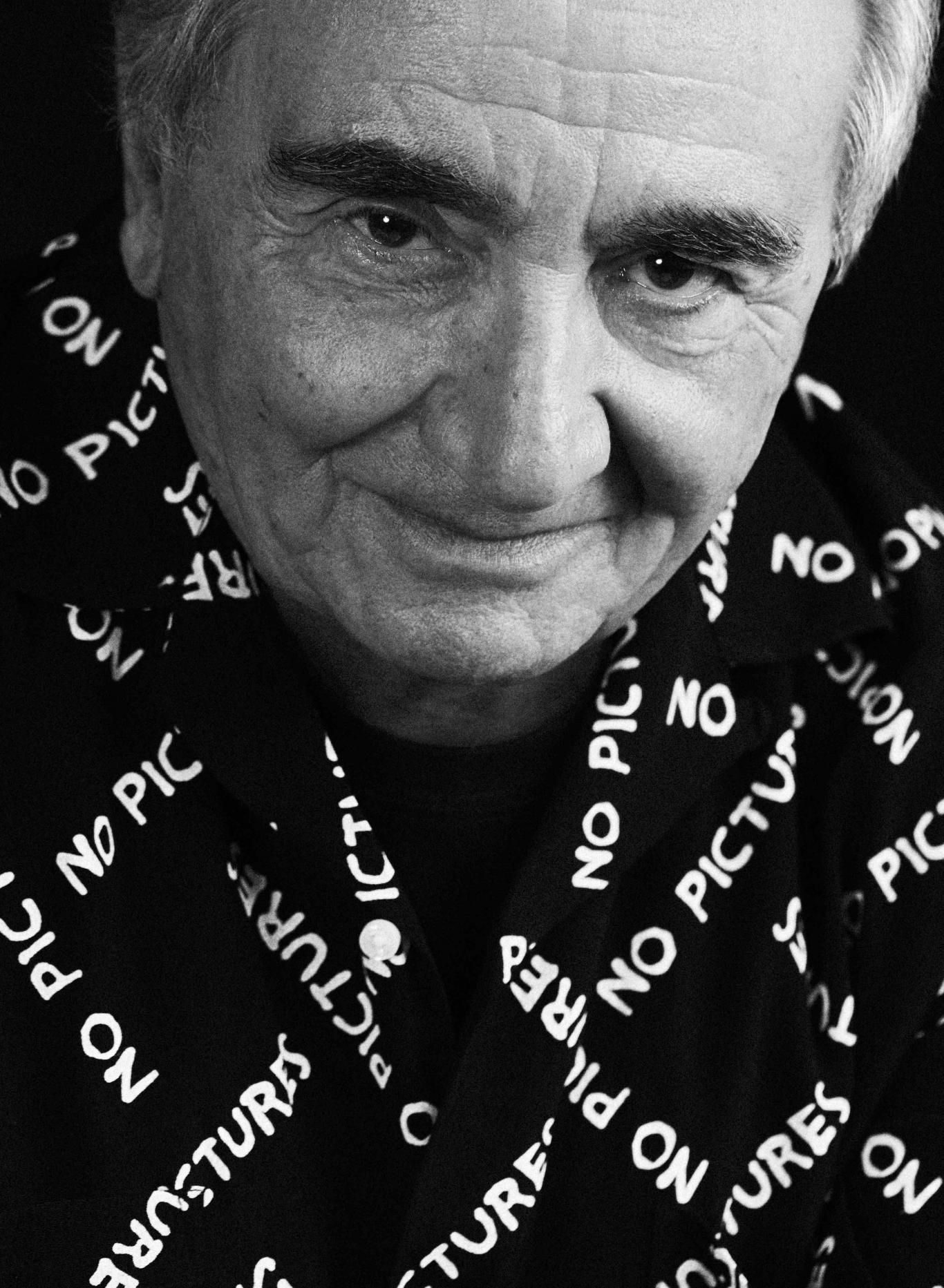 Retrato de un hombre mayor con camisa negra con letras blancas