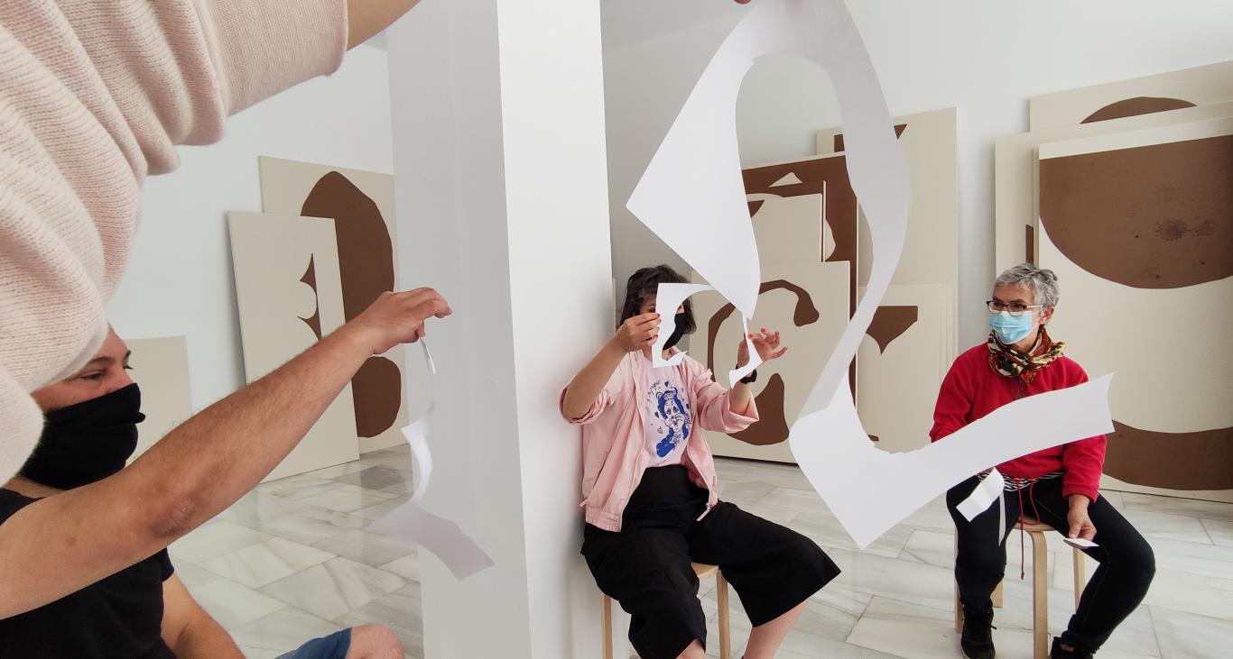 Varias personas en la sala de exposiciones interactuando con obras