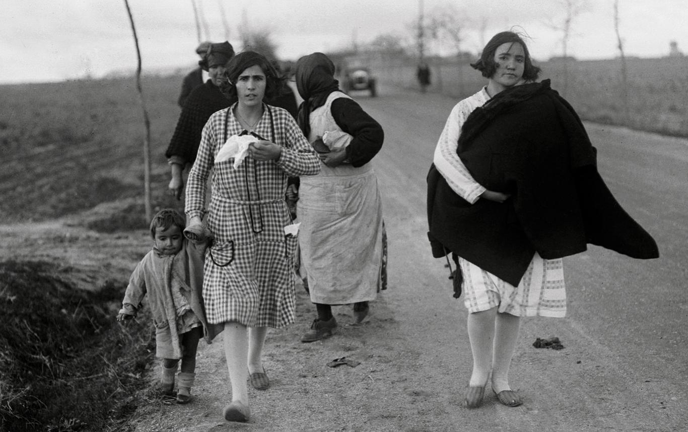 Mujeres y niños caminando por una carretera