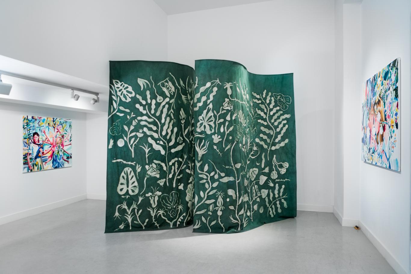 Telón de tela verde con dibujo de ramas y hojas simulando un bosque