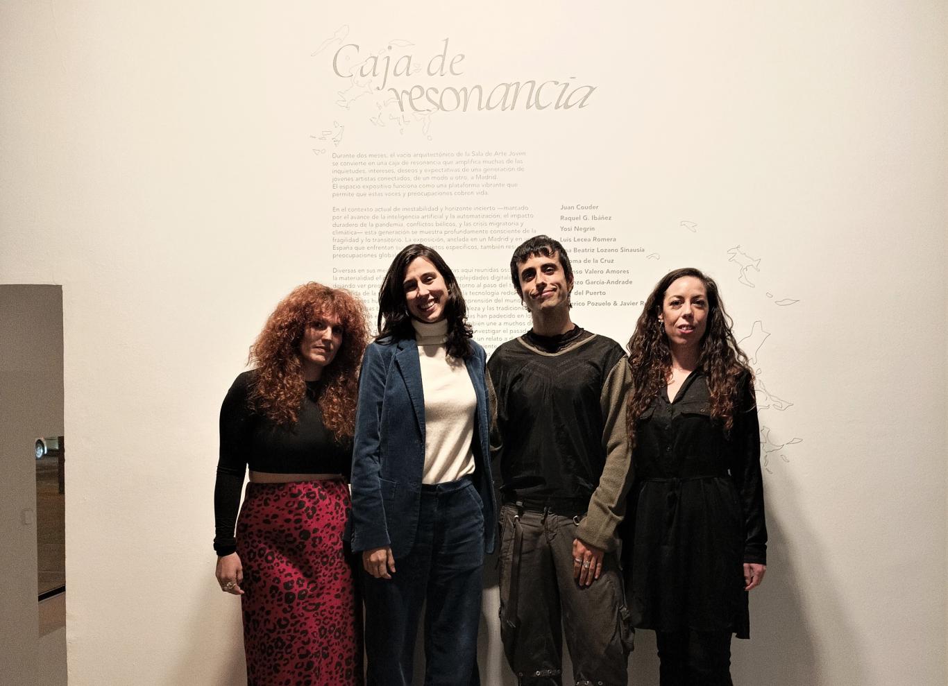 Group of young people posing in front of a text in an exhibition hall where the title of the exhibition is read A paradigm shift