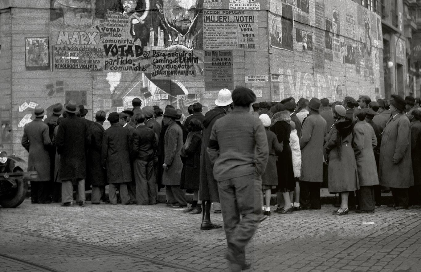 Hombres y mujeres contemplando propaganda electoral 