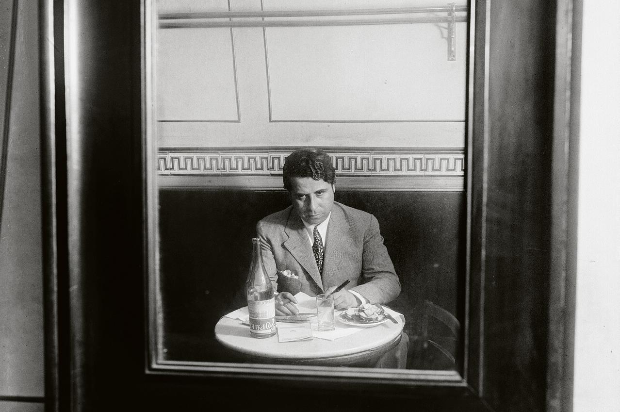 Hombre sentado en un café reflejado en un espejo
