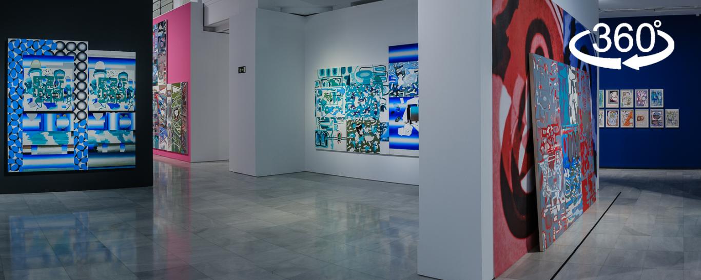 An exhibition hall with large canvases painted in bright colors and abstract figures