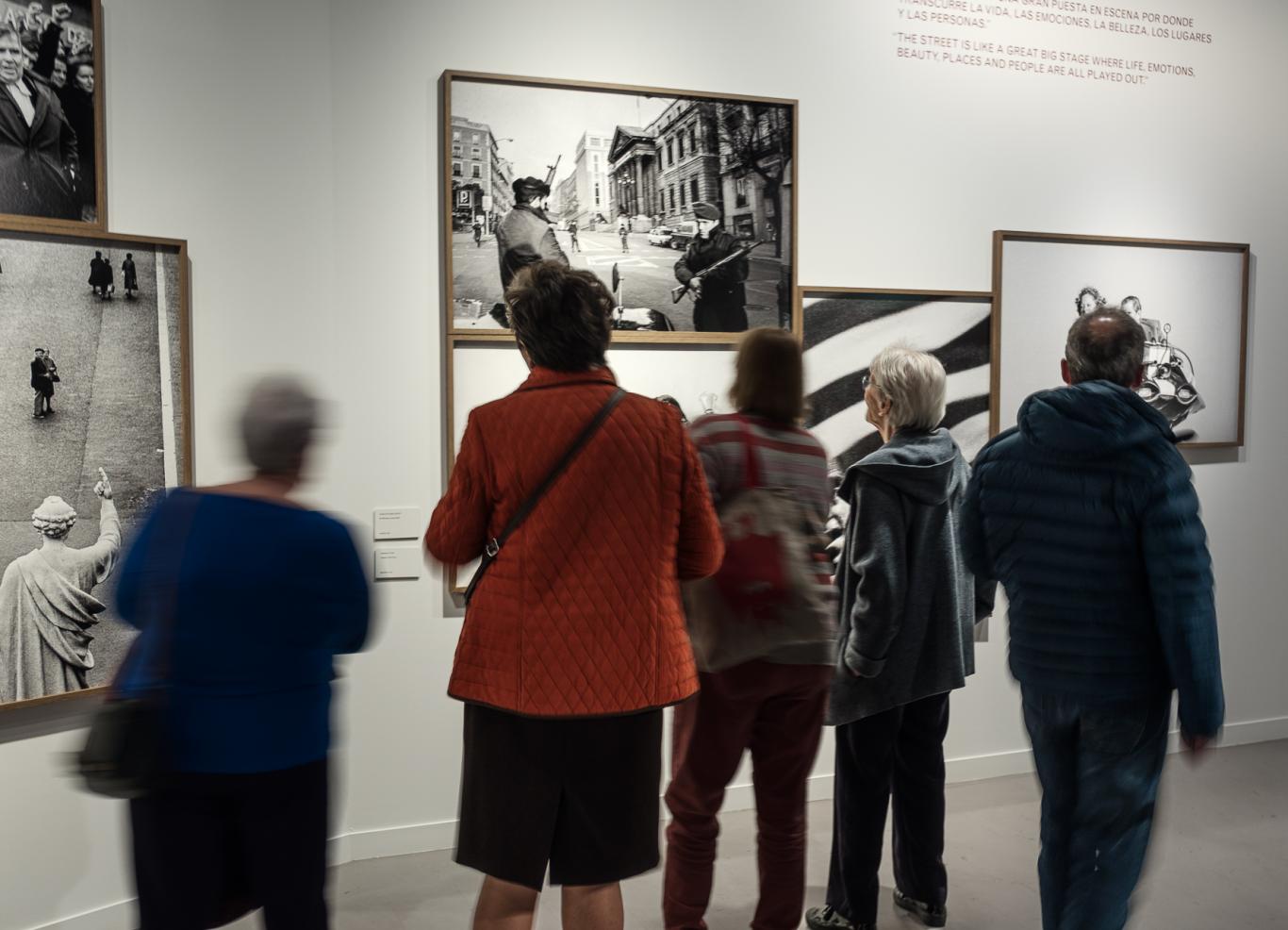 Grupo de personas visitando una sala de exposiciones de fotografía