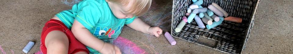 Niño pintando con tizas.
