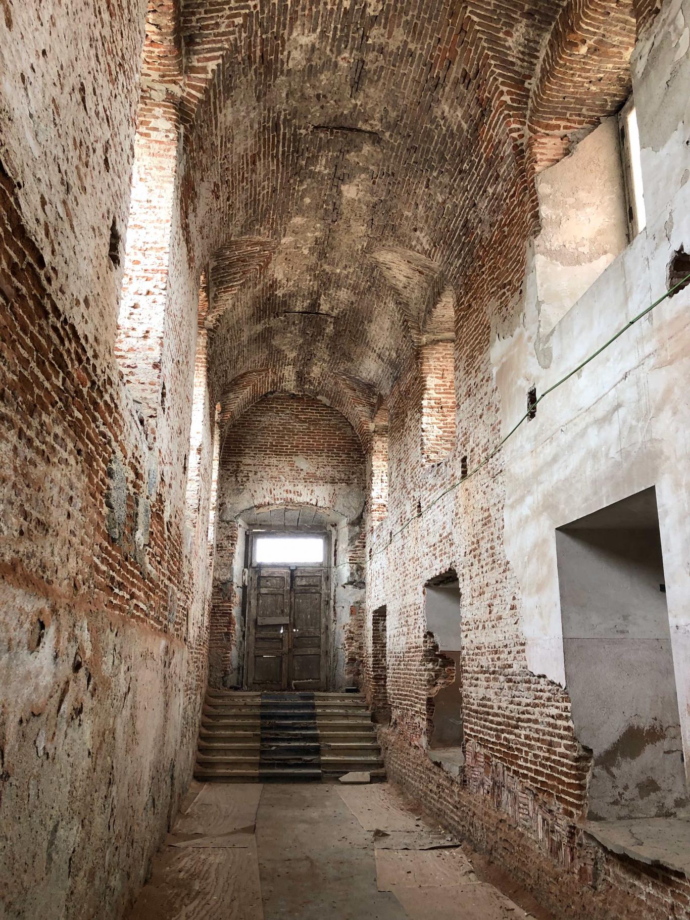 Double-height gallery with brick walls and large windows