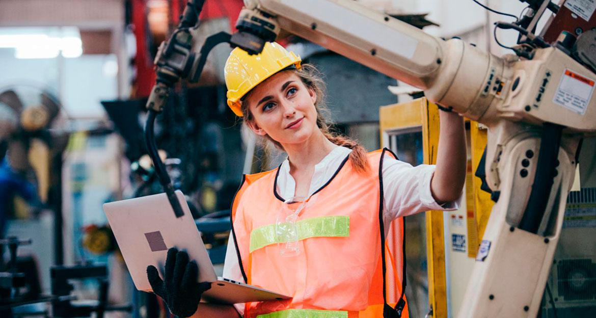 Mujer trabajando ante un brazo robótico