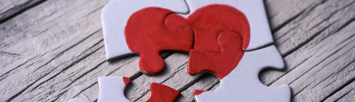 puzzle de cuatro piezas con un corazón rojo como tema principal