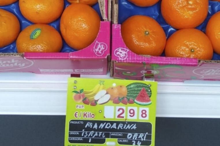 Imagen de naranjas bien etiquetadas a granel en un expositor