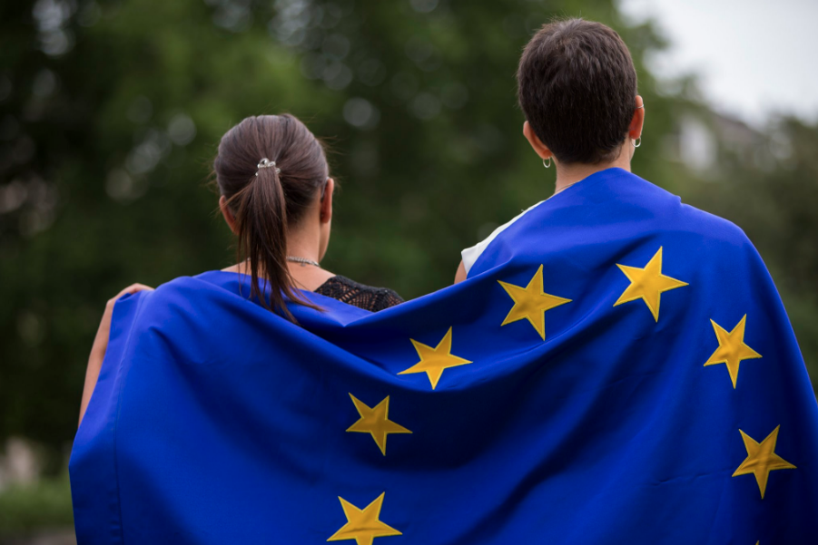 Chicas de espaldas con la bandera de europa