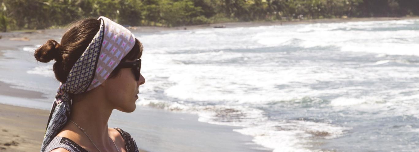 chica en playa mirando al mar