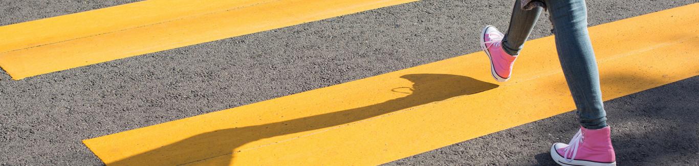 Joven cruzando paso de cebra amarillo