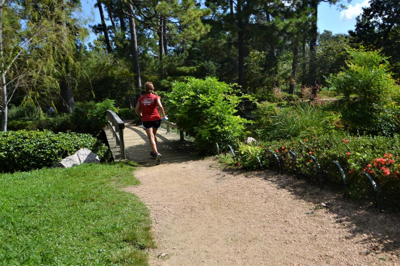 chica cruzando puente en un parque