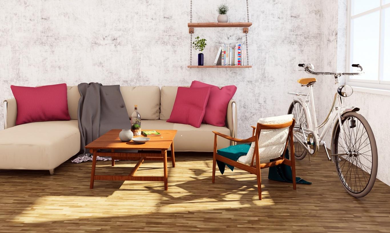 sofa con cojines, mesa, bicicleta dentro de una sala 