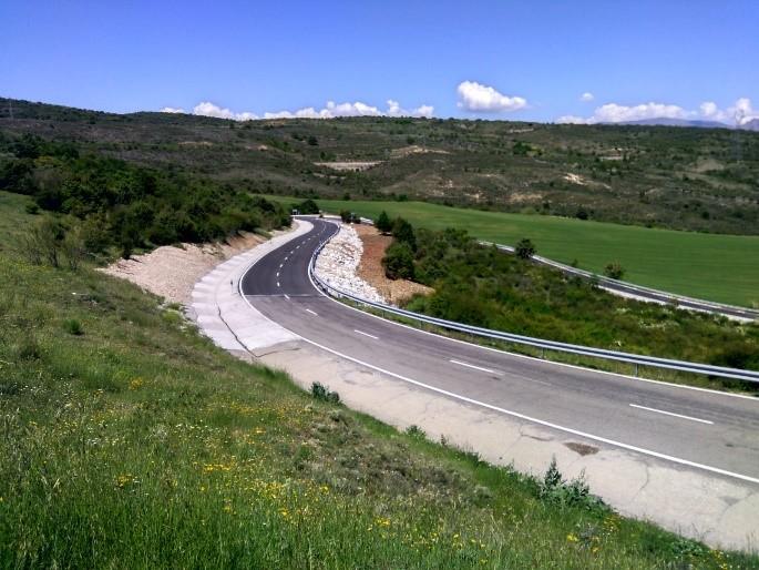 Carretera en el Vellón en obras, con campo verde a ambos lados