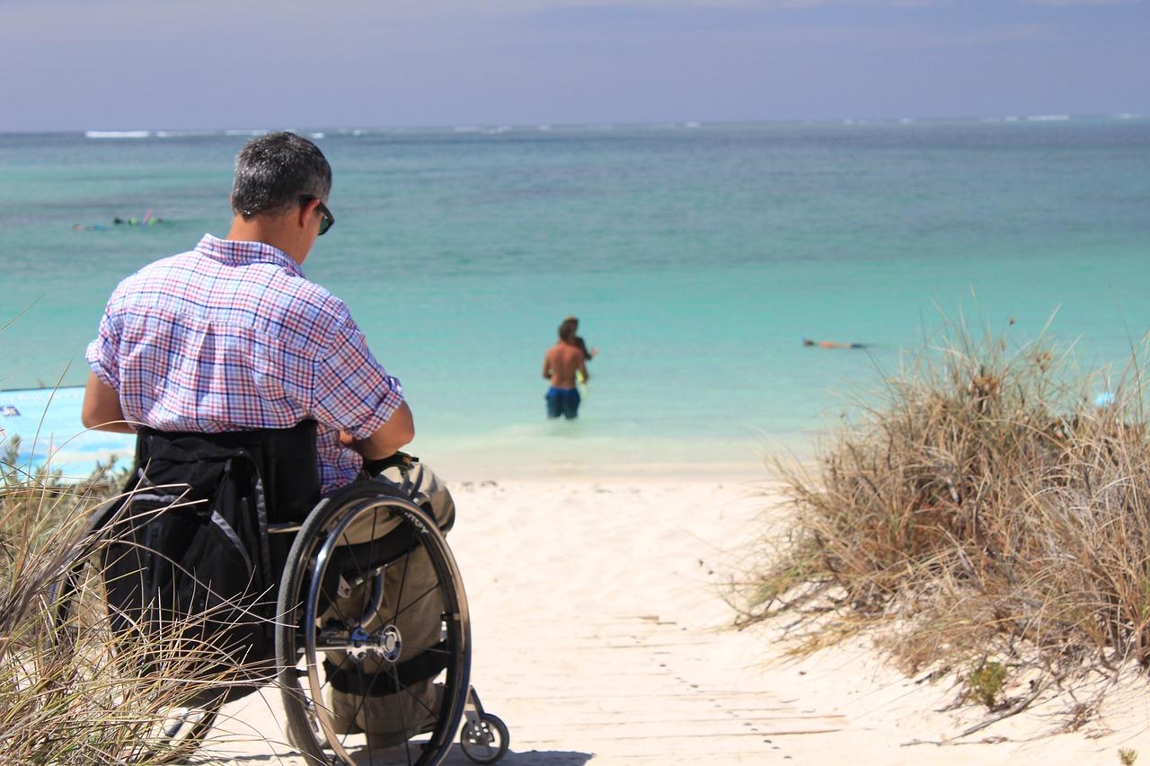 imagen de hombre en silla de ruedas en la playa