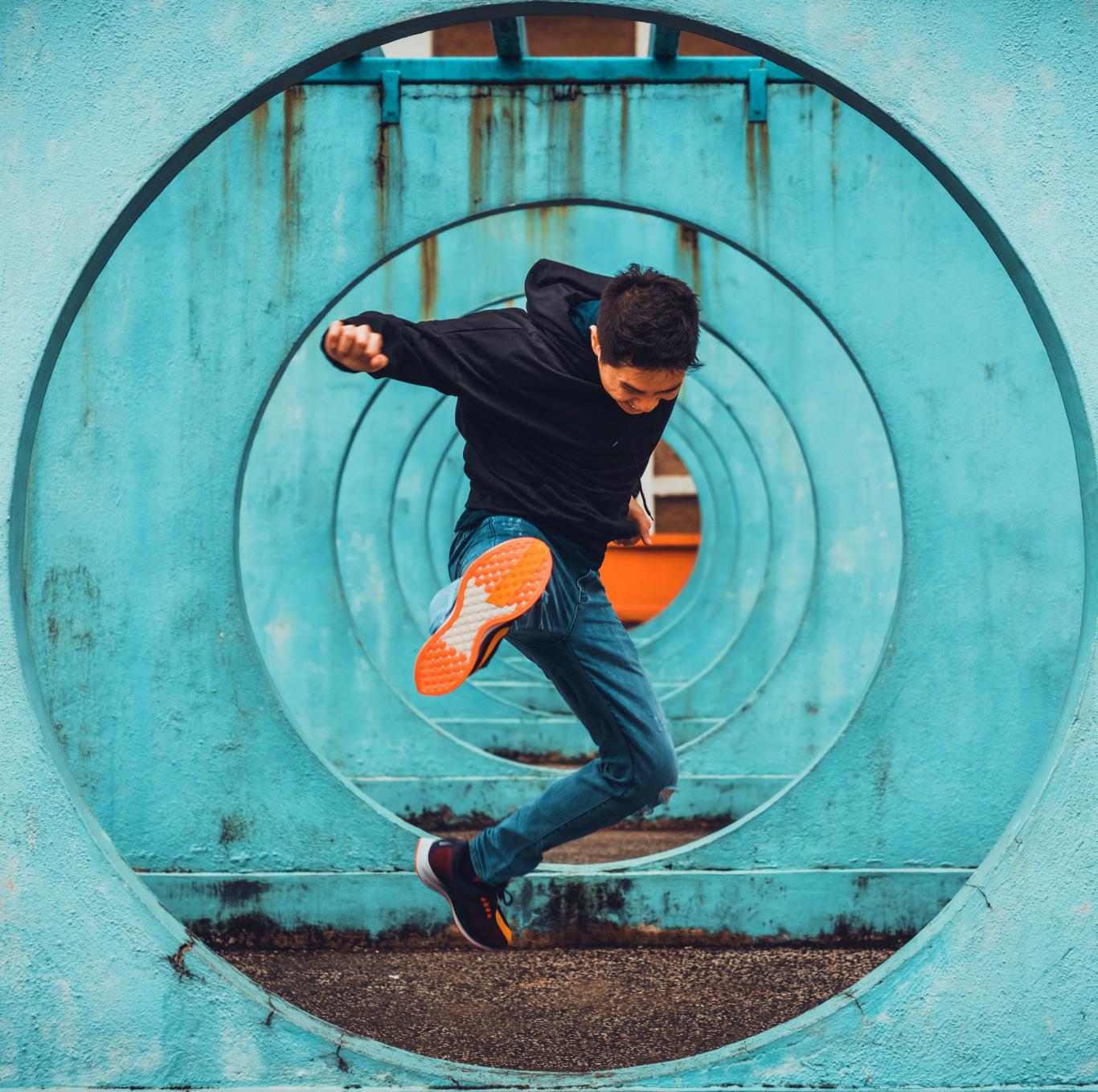 Joven haciendo salto en el aire y patada con una pierna