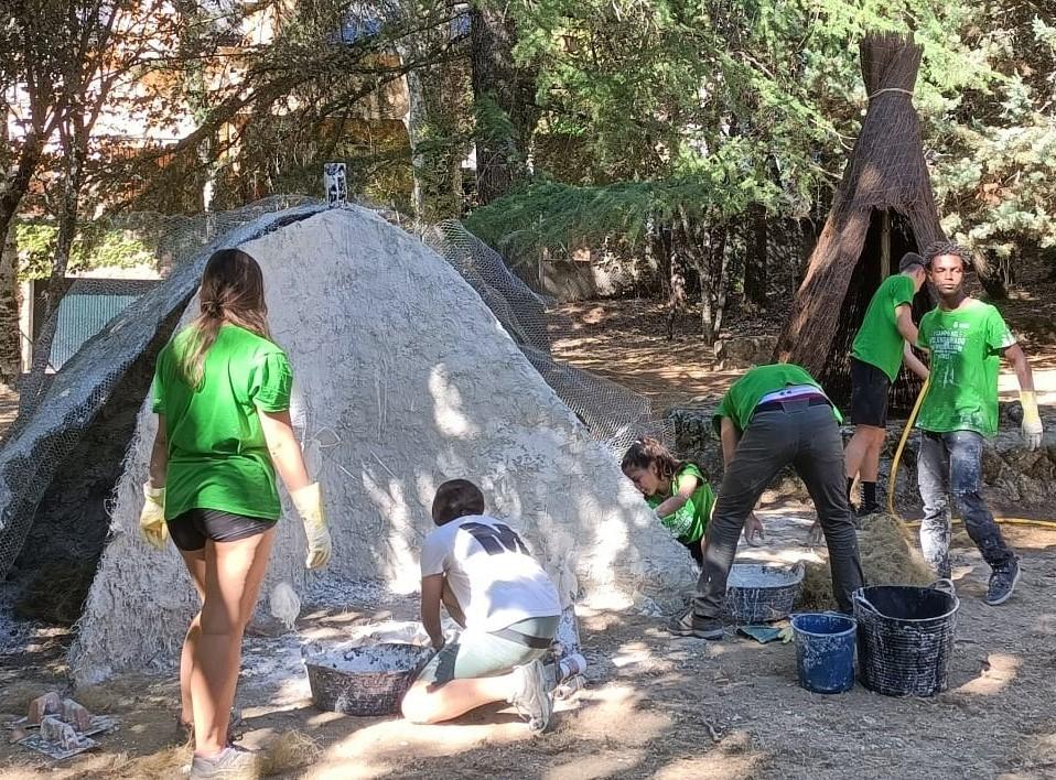 Jóvenes trabajando construyendo una choza