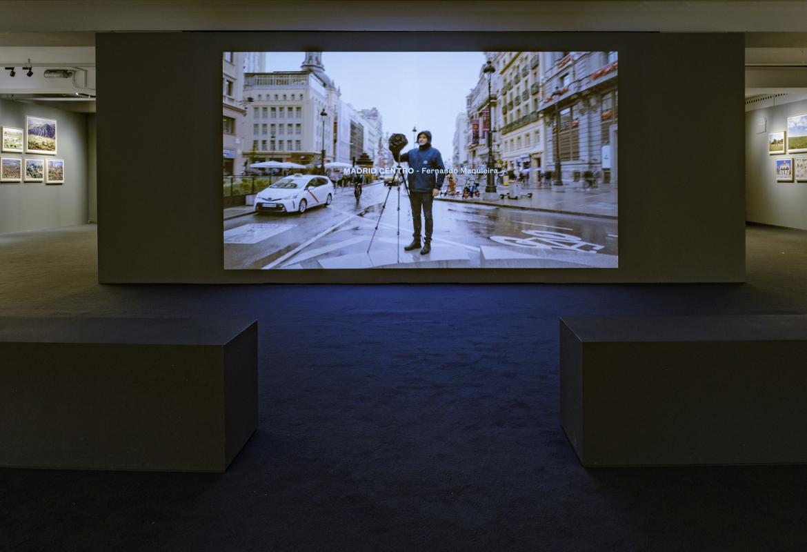Vista de la sala de exposiciones, exposición REGIÓN, Paisaje, fotografía y patrimonio, se aprecia una pantalla con una fotografía de Madrid