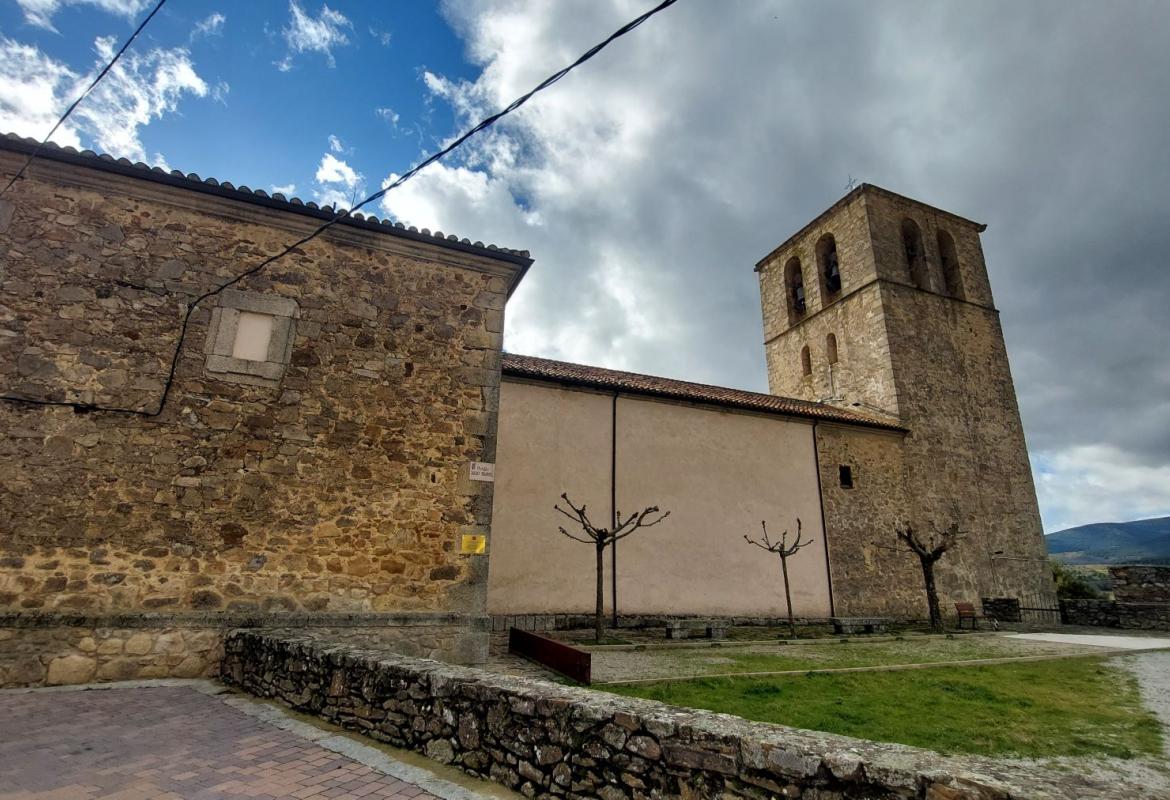 Fachada exterior de una iglesia con torre campanario rectangular 