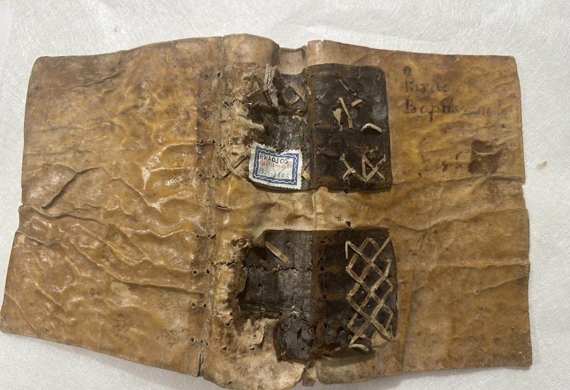 Libro de bautismo antes de la restauración. Encuadernación. Libro de bautismo, abierto por su reverso, antes de la restauración