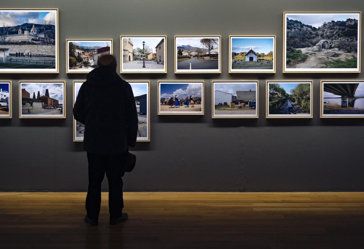 Un visitante observa unas fotografías en la exposición REGIÓN, Paisaje, fotografía y patrimonio