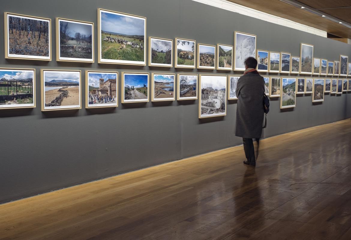 Un visitante observa las fotografías de la exposición REGIÓN, Paisaje, fotografía y patrimonio