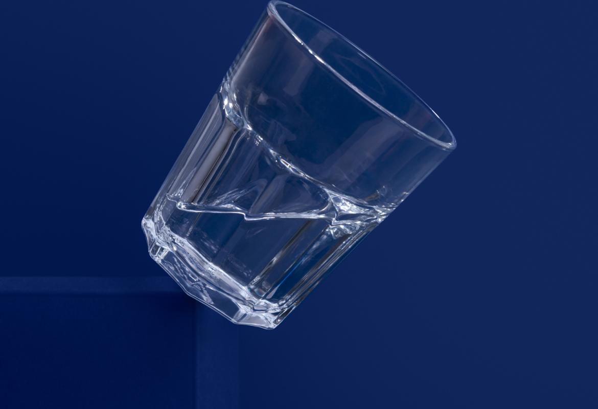 Vaso de agua sobre fondo azul