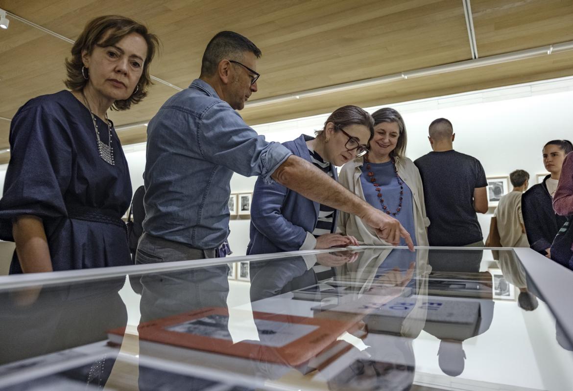 El comisario de la exposición explica las obras de una vitrina de la exposición Madrid Bernard Plossu