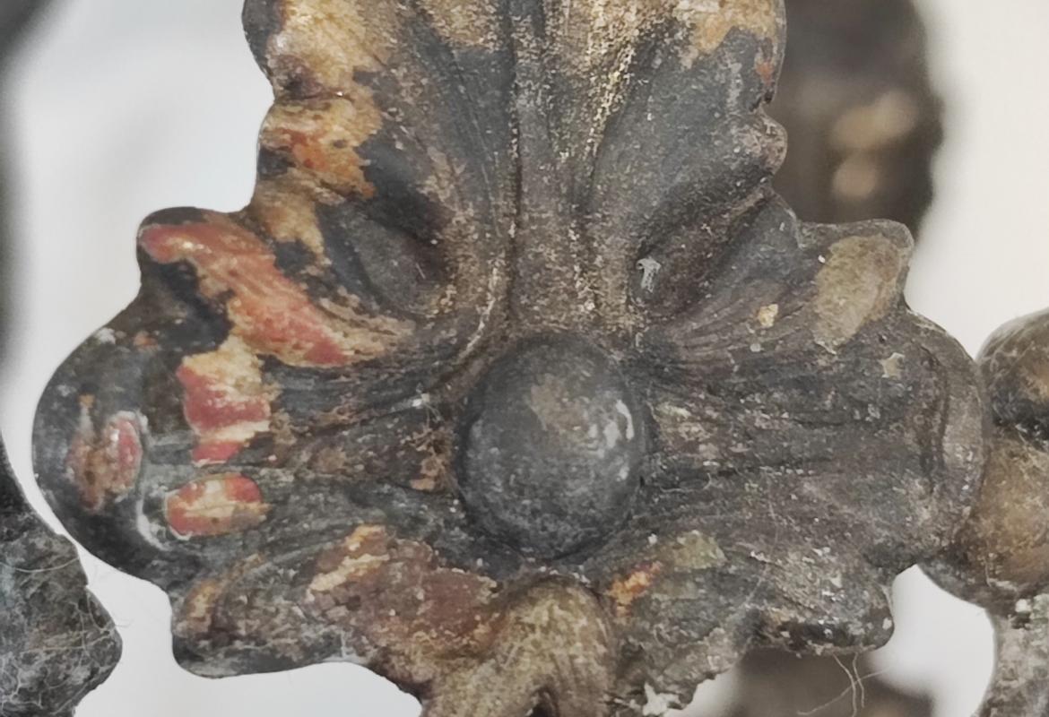 imagen de un fragmento de corona de plata con adornos vegetales en mal estado de conservación