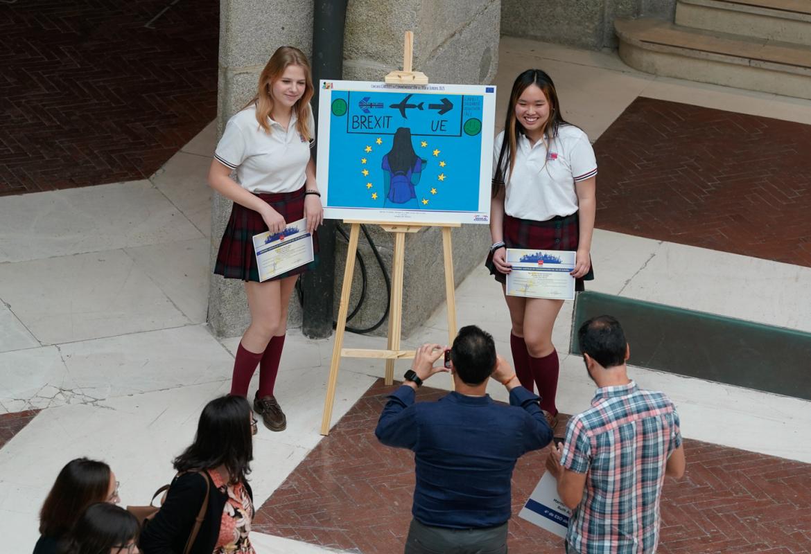 Alumnas ganadoras del premio de Parque de Atracciones Madrid posan ante su cartel ganador