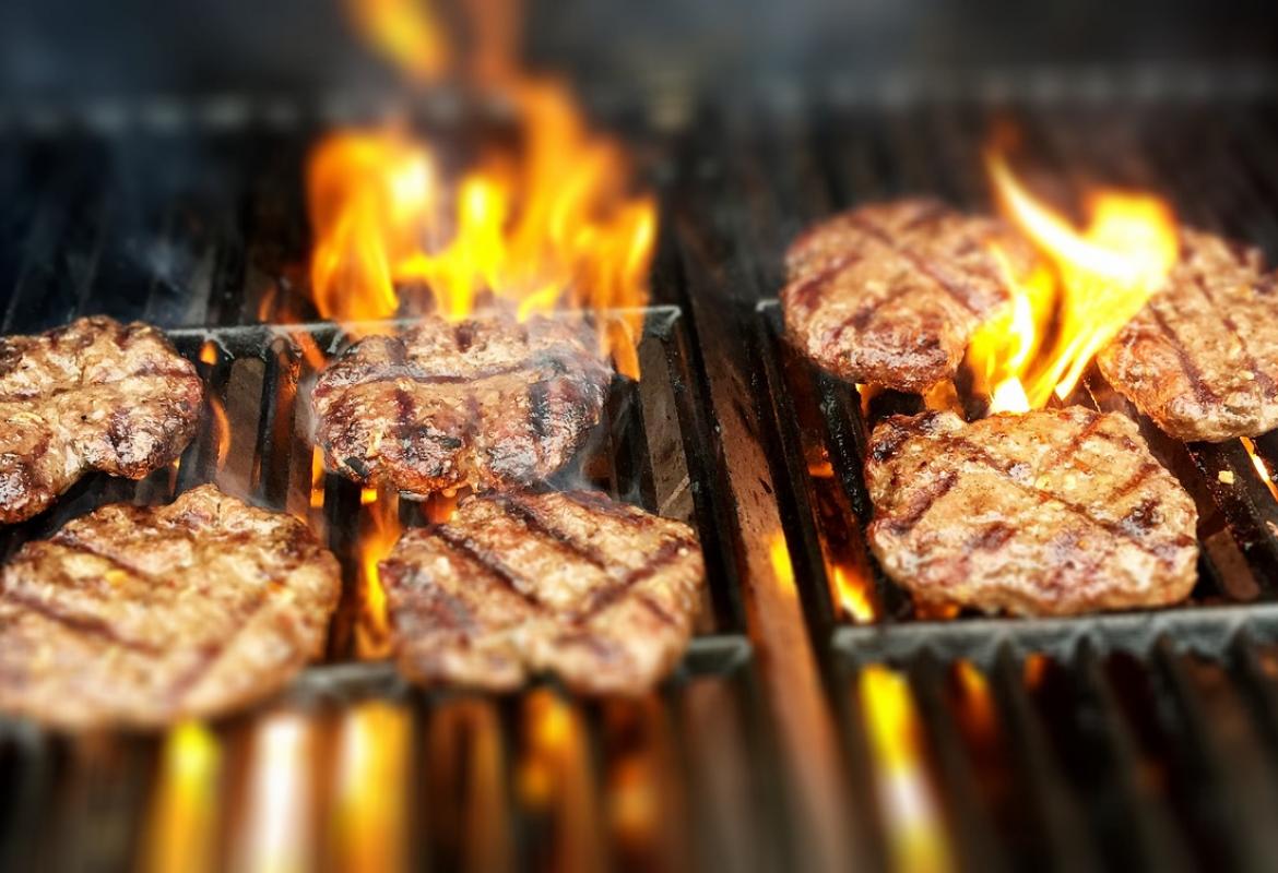 Hamburguesas en la parrilla con fuego vivo
