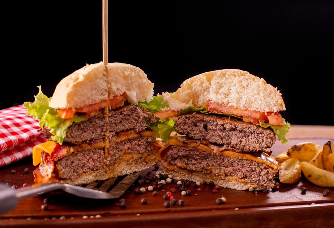 Hamburguesa cortada por la mitad donde se ve que la carne está suficientemente hecha