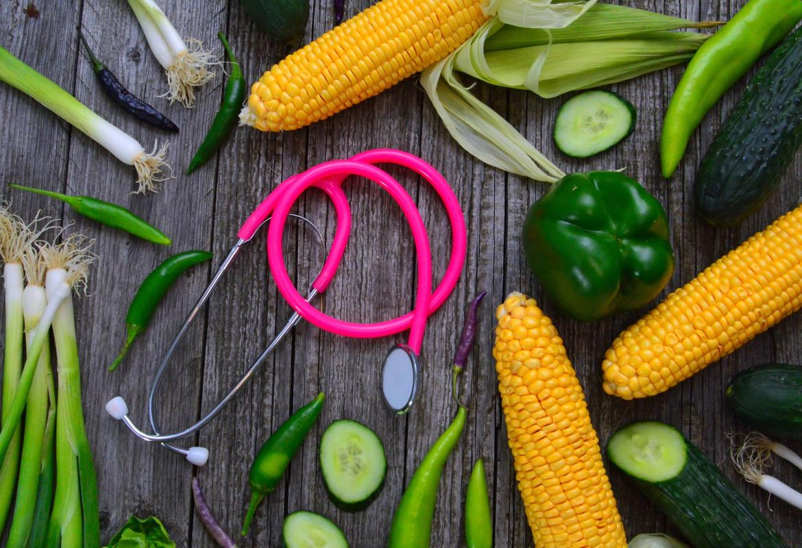 Verduras y estetoscopio sobre una mesa oscura